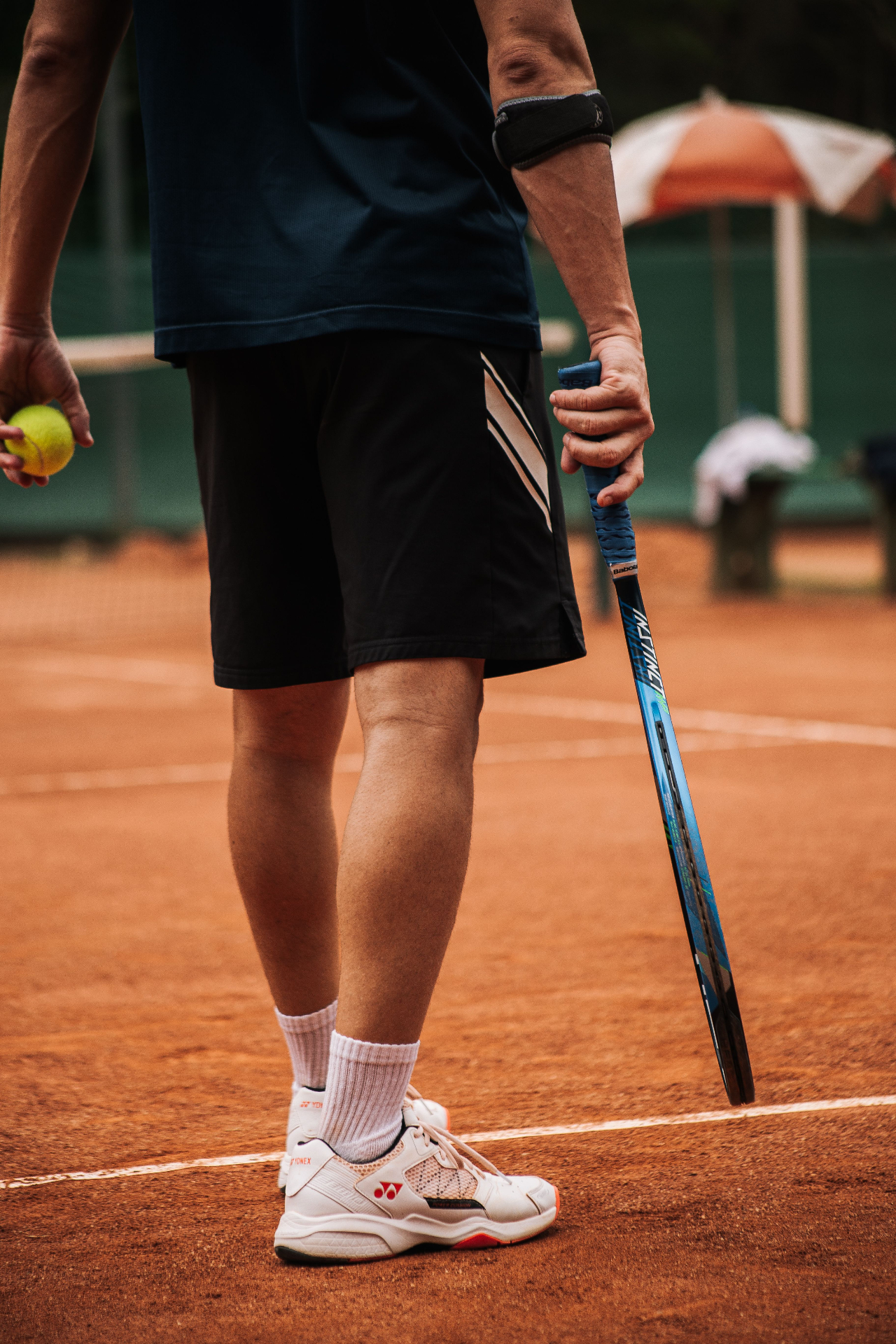 Two athletes in sneakers on a concrete tennis court, representing team and sport